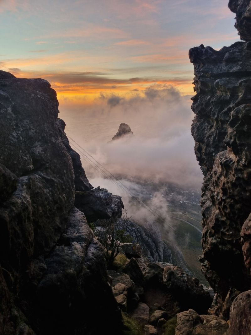 Cloud drifting through a gap in the rocks on Table Mountain's front face, lit by a low sun