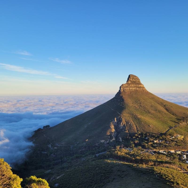 Lion's Head rising above a sea of cloud on a clear morning, with the Atlantic beyond